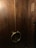 A set of large wooden double doors with a dark brown finish, featuring circular metal handles. There is a wooden plaque with Korean characters on the right side.