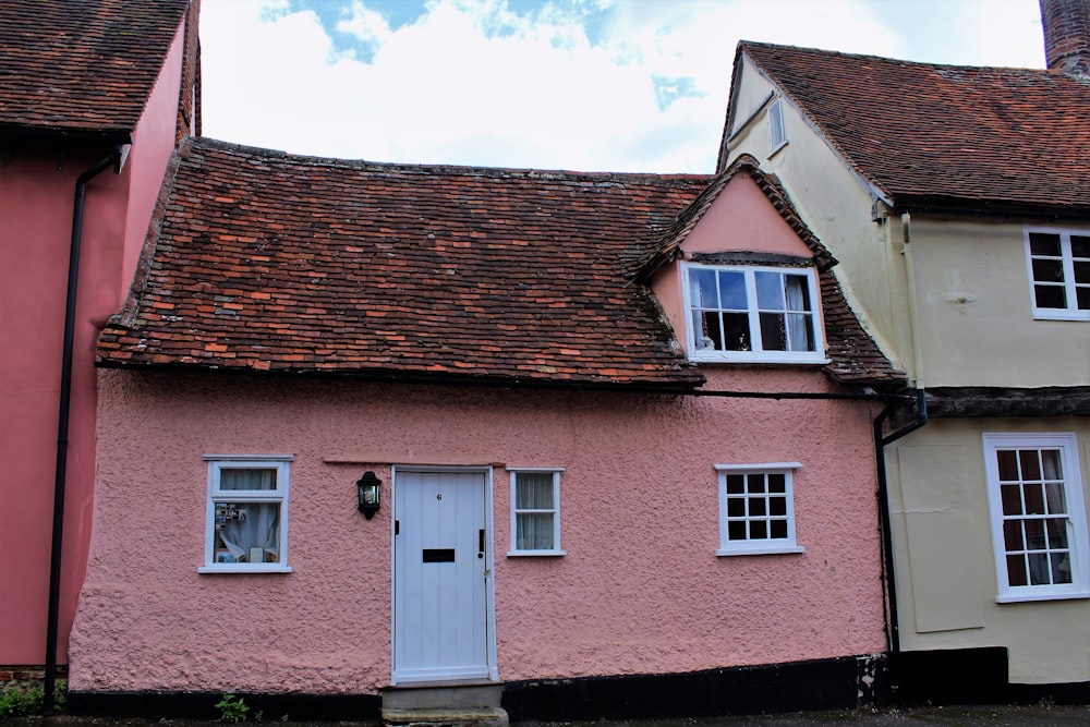 pink and brown house under cumulus clouds