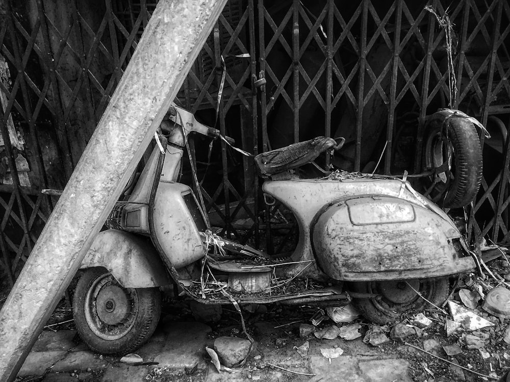 motor scooter beside grey metal gate during daytime