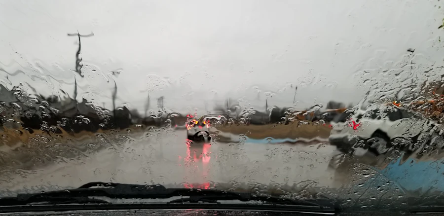 View through a rain-covered windshield on a wet road