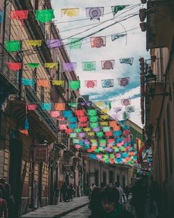 A vibrant street scene in Puebla with colorful papel picado decorations and traditional Mexican architecture.