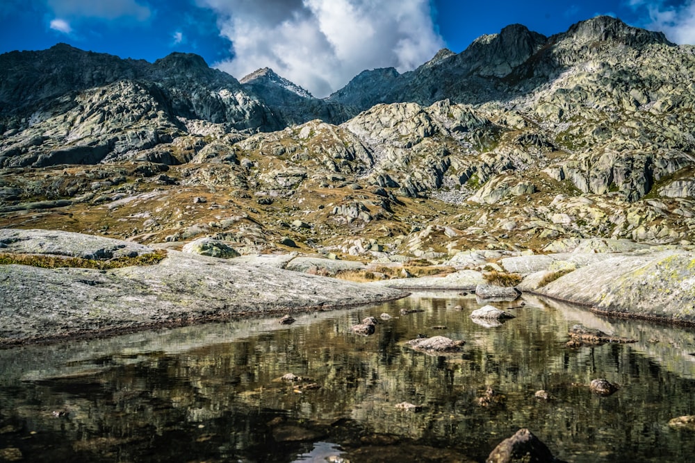 fotografia di paesaggio dello specchio d'acqua accanto alle catene montuose