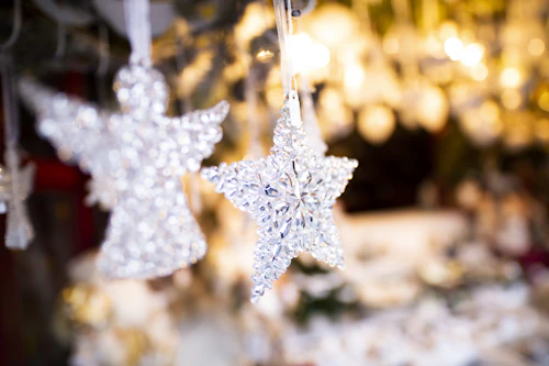 A set of glass angel and star ornaments in soft white and blue tones.