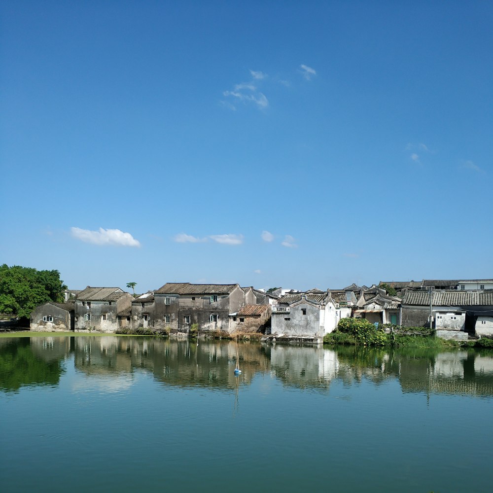 Reflektierende Fotografie eines Dorfes in der Nähe eines Gewässers