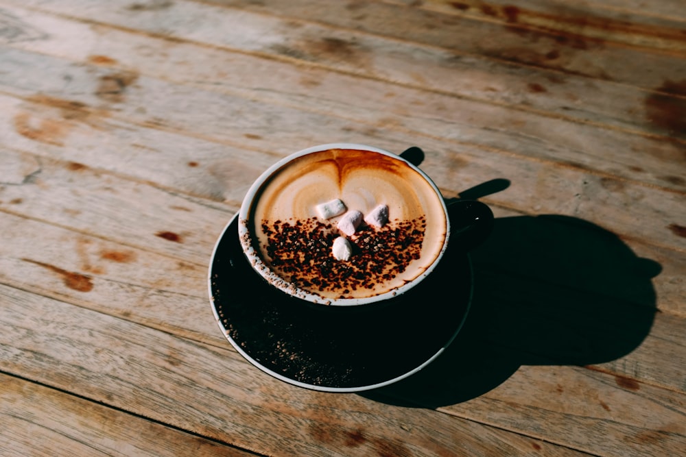 coffee in teacup with saucer on brown wooden surface