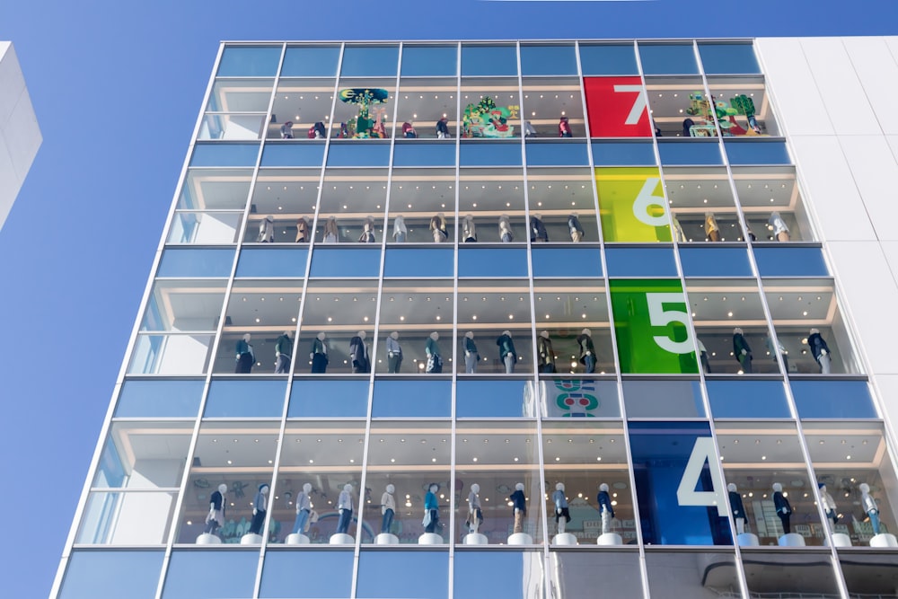 mannequin lot displaying on clear glass curtain building during daytime