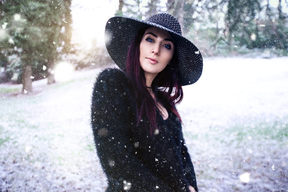 woman wearing black sun hat standing near trees during daytime