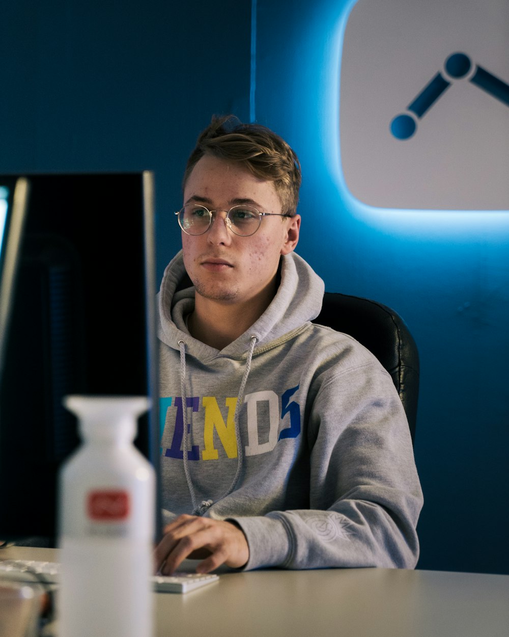 selective focus photography of man sitting on chair facing monitor