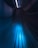 A futuristic hallway with sleek, curved lines and a glowing central strip of blue light extending towards a vanishing point, creating a sense of depth and motion.