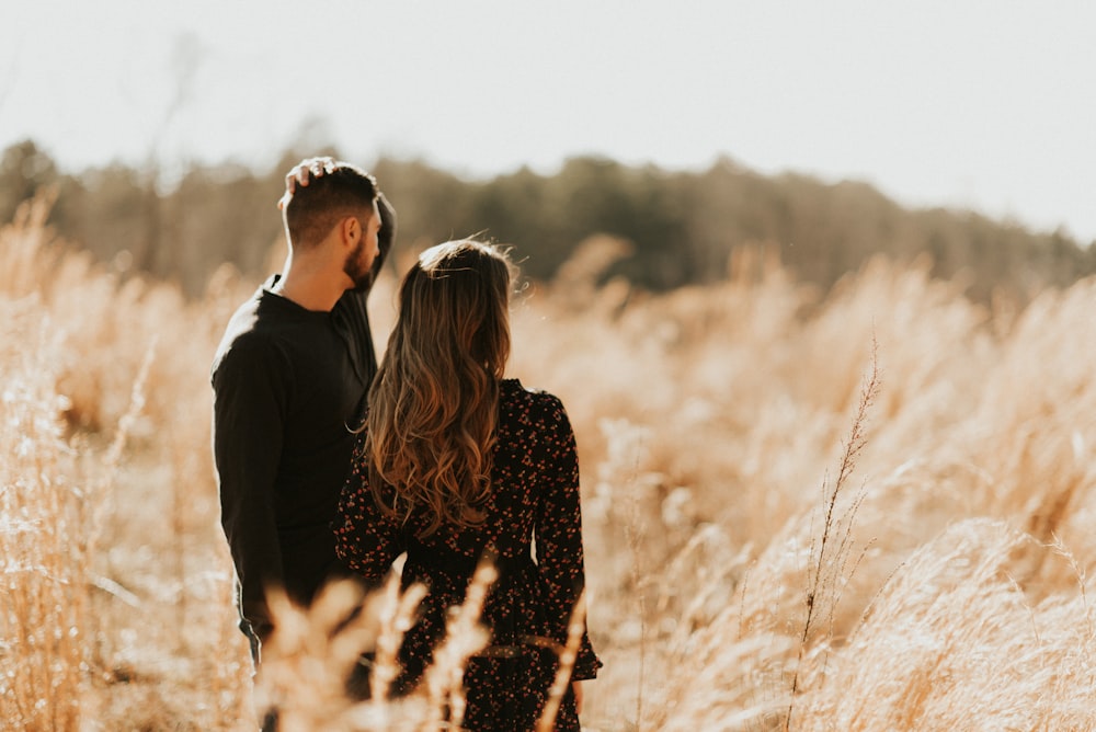 man and woman standing at middle of grasses