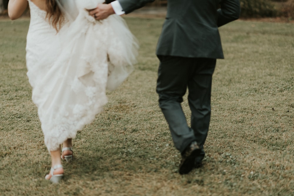 wedded couple walking on grass field