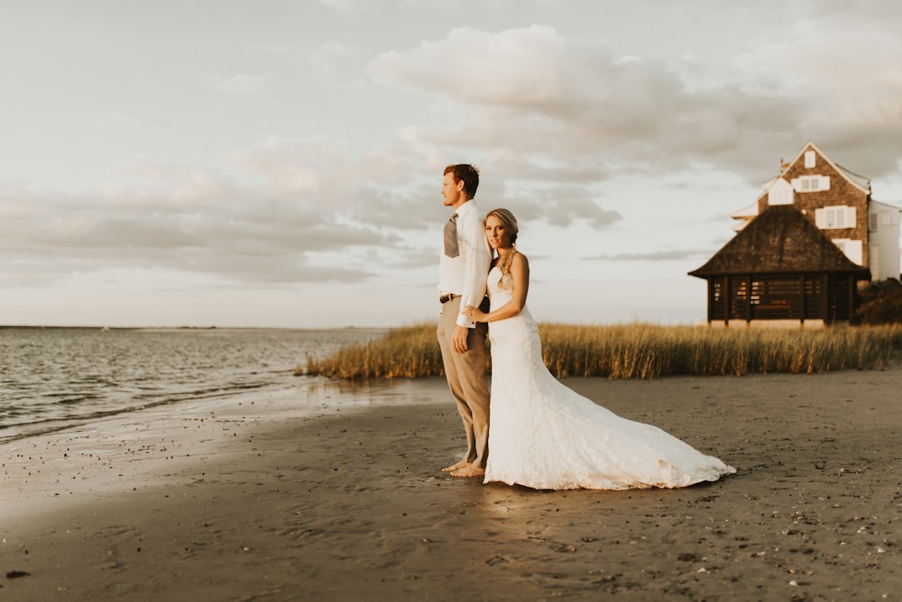 couple standing beside beach during daytime