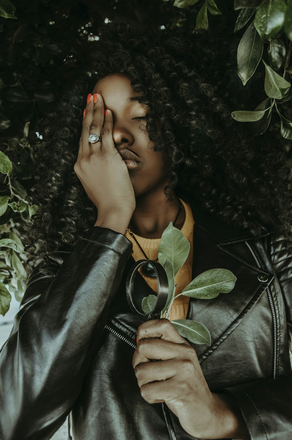 woman in black coat surround by leaves on focus photography