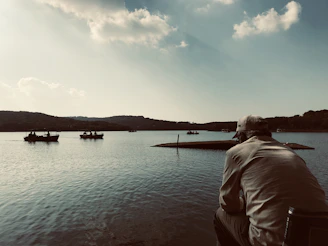 A serene lakeside scene with a straw hat placed on a picnic blanket.