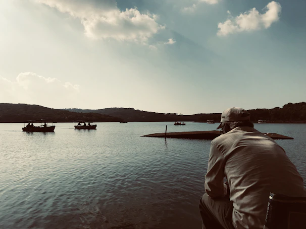 A serene lakeside scene with a straw hat placed on a picnic blanket.