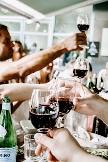 A group of travelers tasting wine at a rustic cellar, laughter and glasses raised.