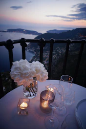 two clear wine glass beside tealight candle on table