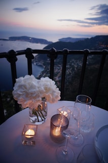 two clear wine glass beside tealight candle on table
