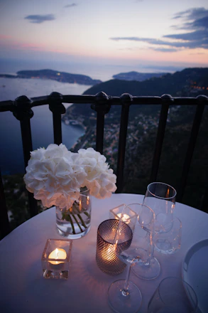 two clear wine glass beside tealight candle on table