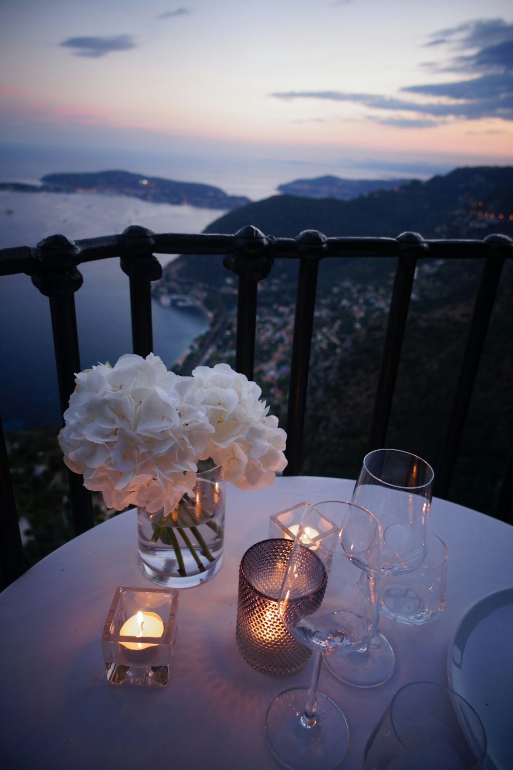 테이블에 tealight 촛불 옆에 두 개의 맑은 와인 잔