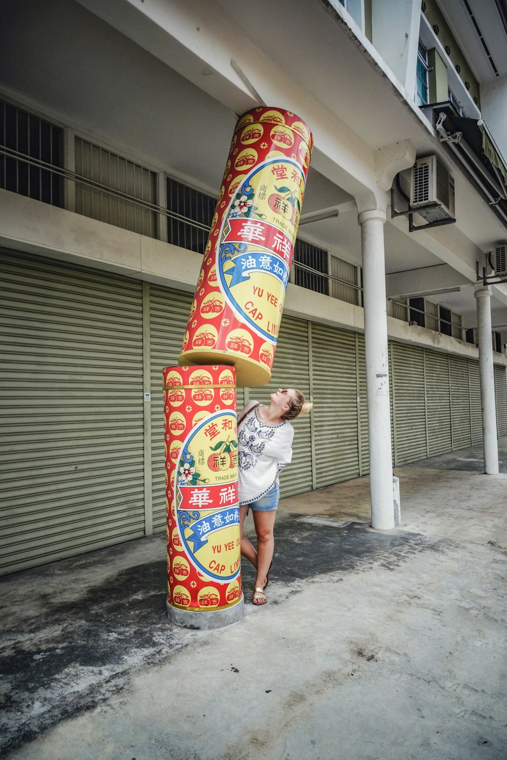 woman standing near red and yellow post