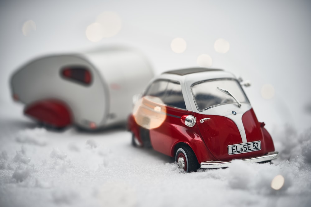 red and white car scale model on white snow field in close-up photography