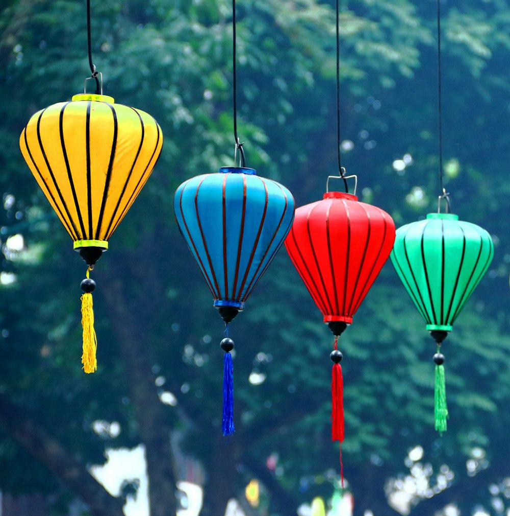 four assorted-color hanging lanterns at daytime