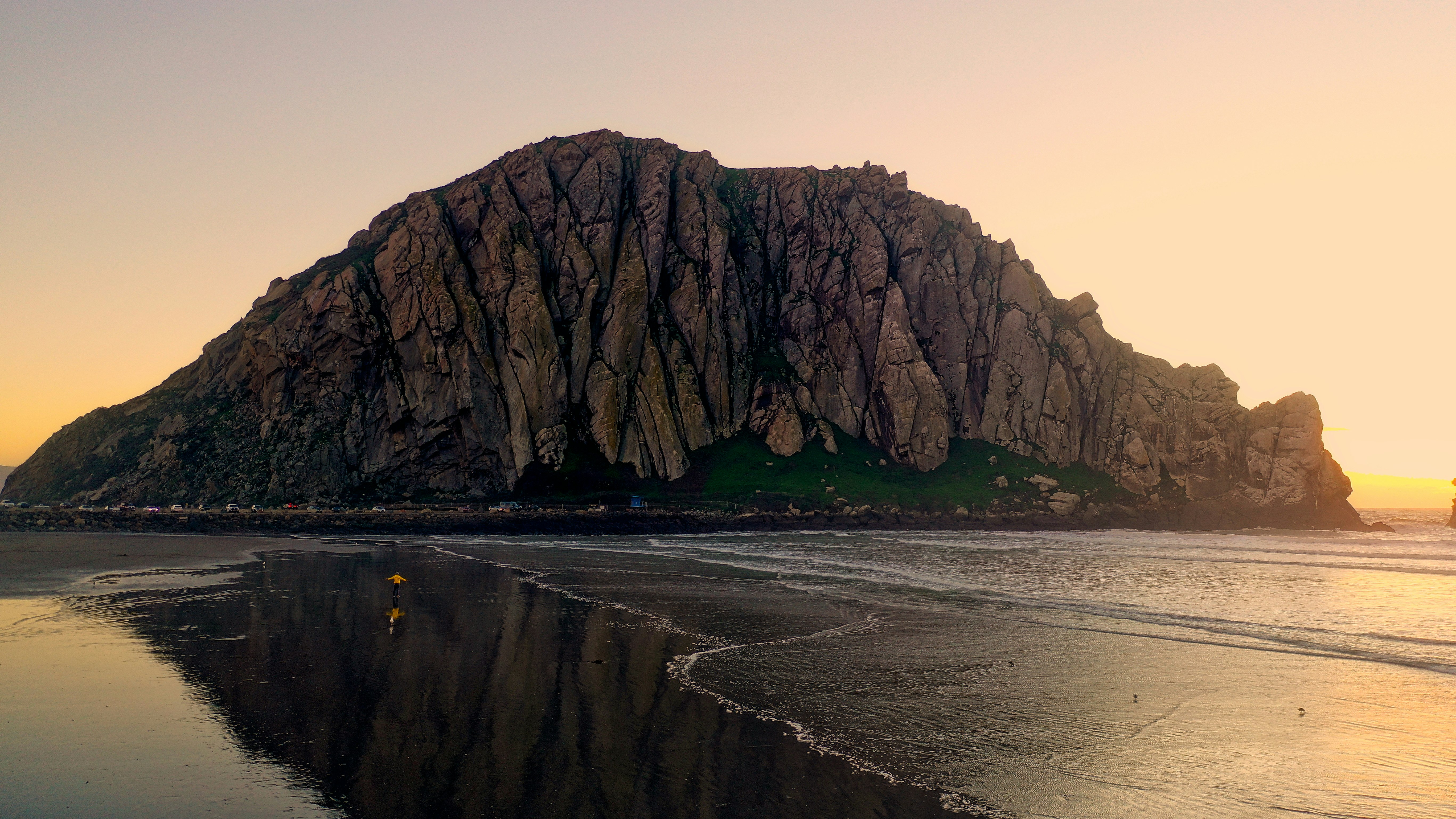 brown rock formation surrounded by body of water during golden hour