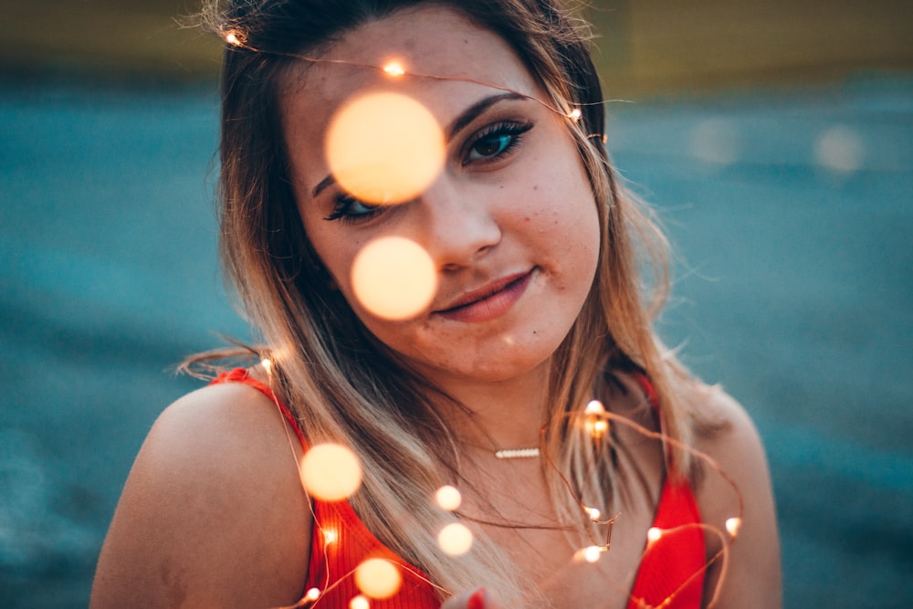 shallow focus photo of woman in red spaghetti strap top