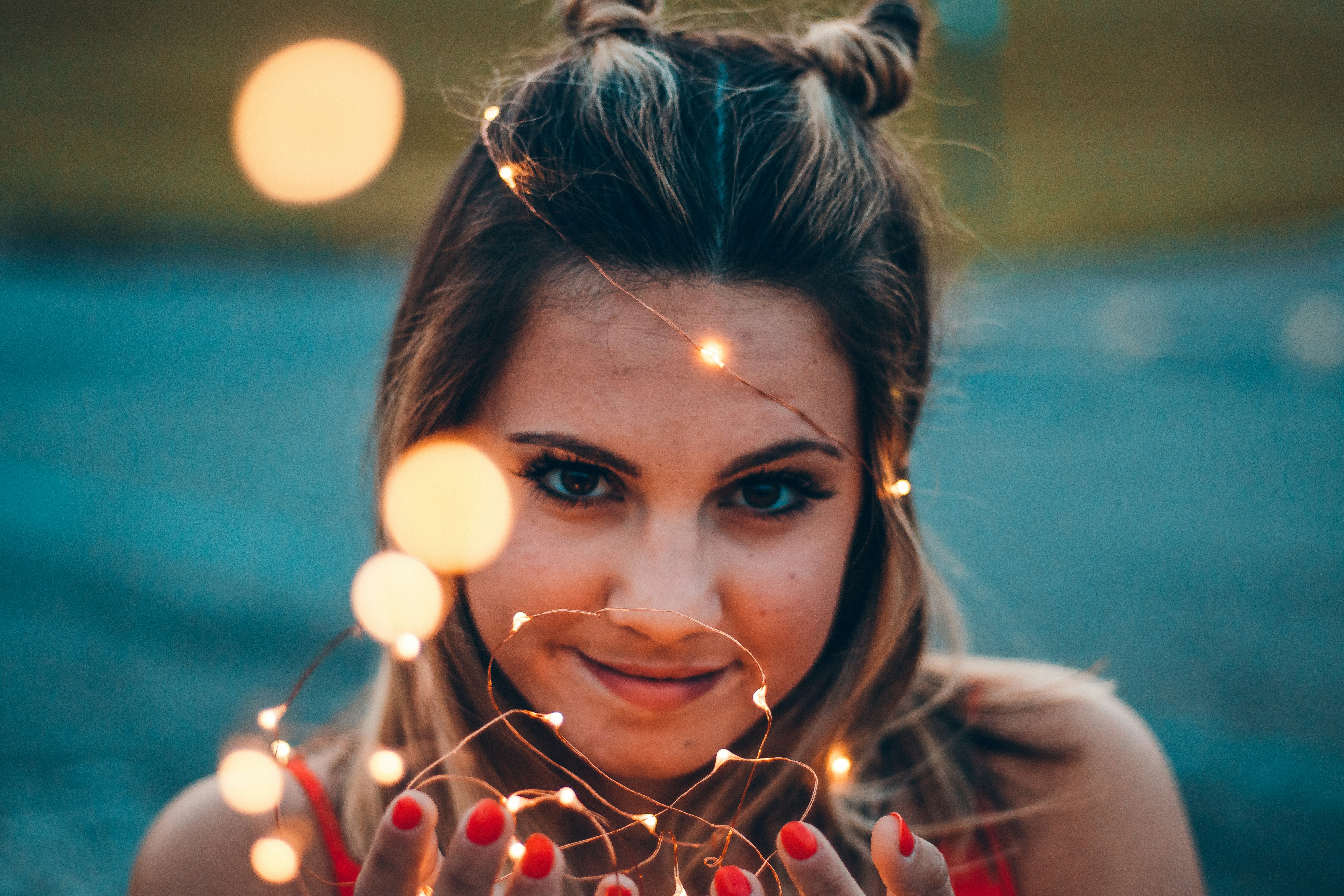 Photographie sélective de mise au point d’une femme tenant une guirlande lumineuse