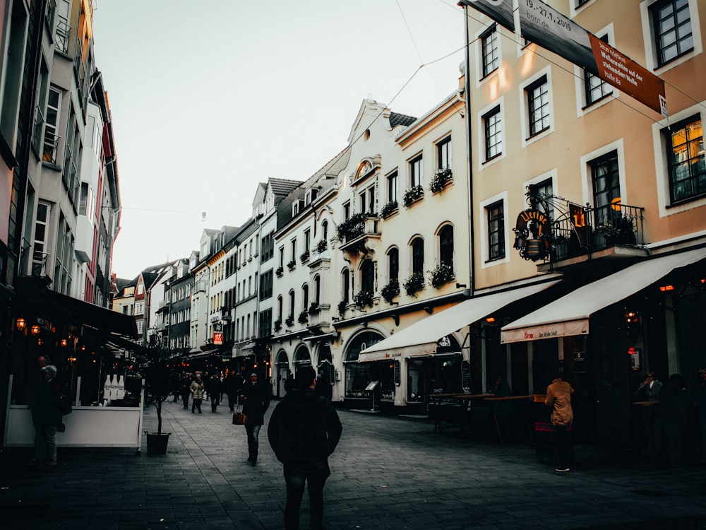 crowd of people walking between buildings at daytime