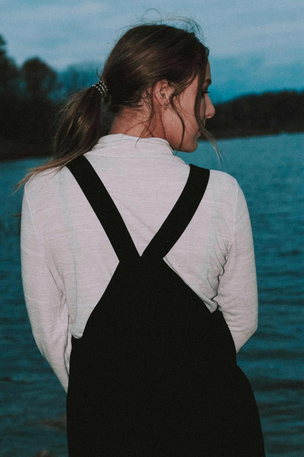 woman in black and white top facing blue sea