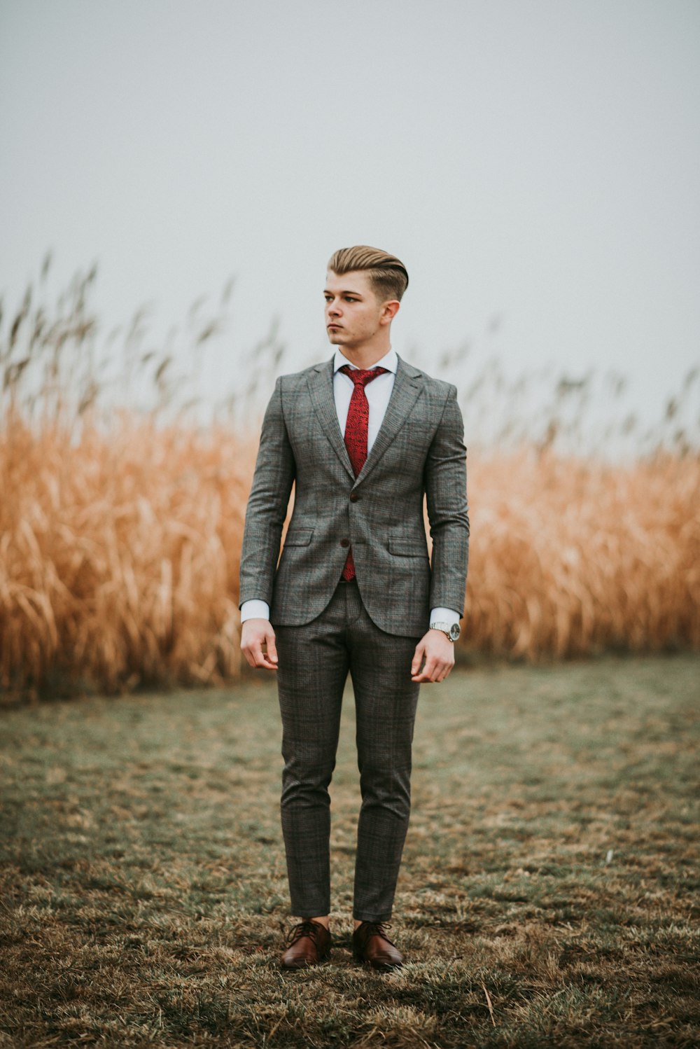 man standing near brown grass field on selective focus photography