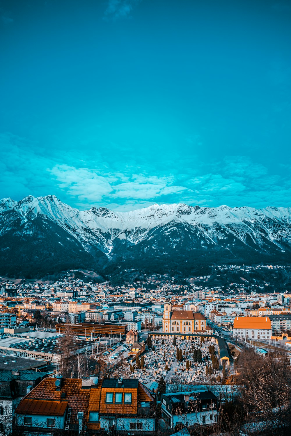 city buildings near snow covered mountain during daytime