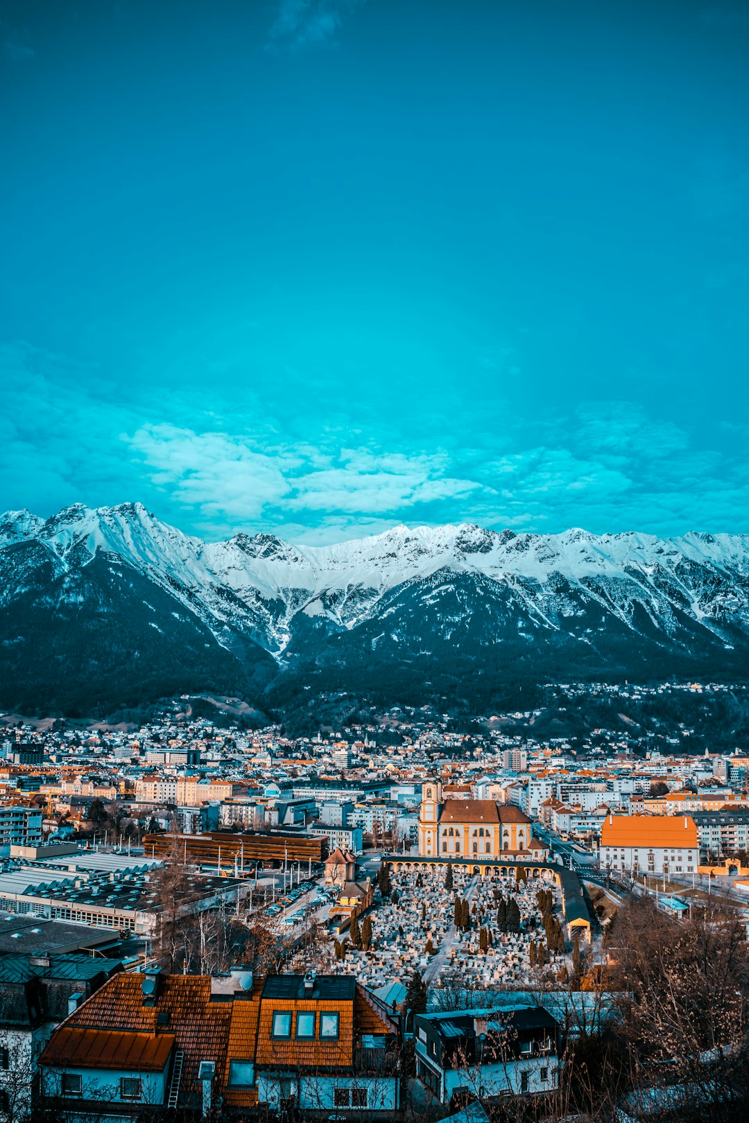 city buildings near snow covered mountain during daytime