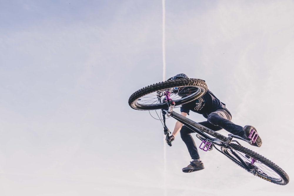 man riding bike under white sky