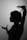 A silhouette of a person with short hair and expressive hand gestures, set against a plain background. The person's profile and hands are sharply defined, creating a dramatic contrast.