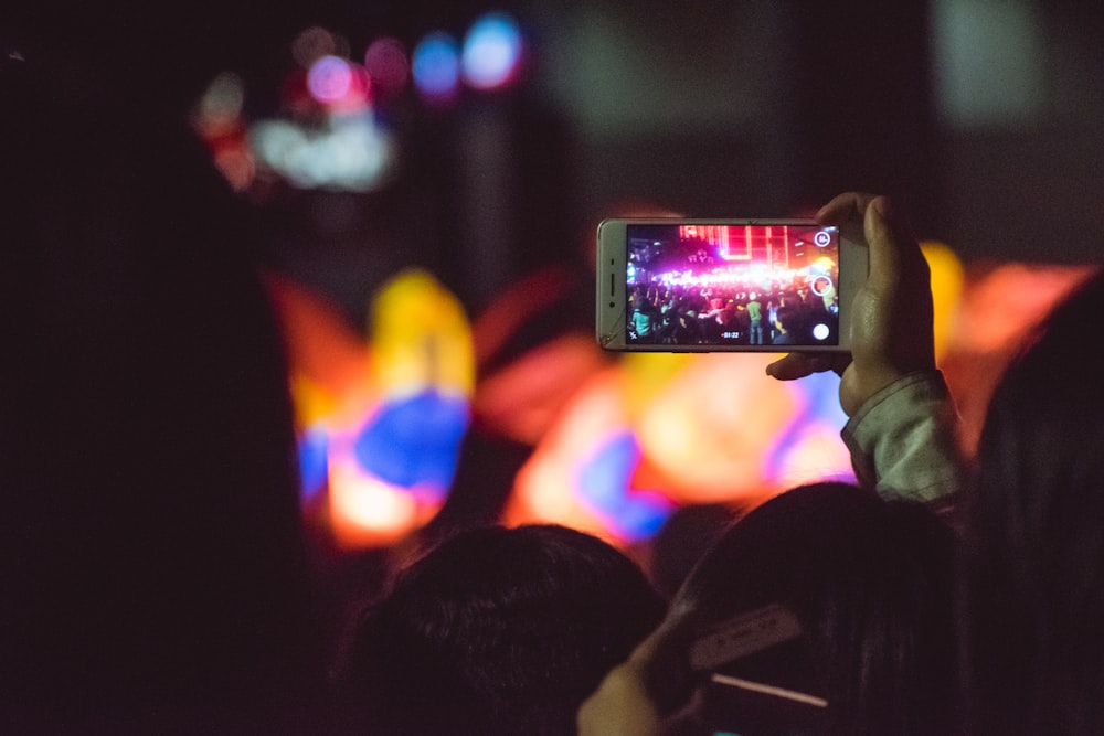 person taking photo of pink light