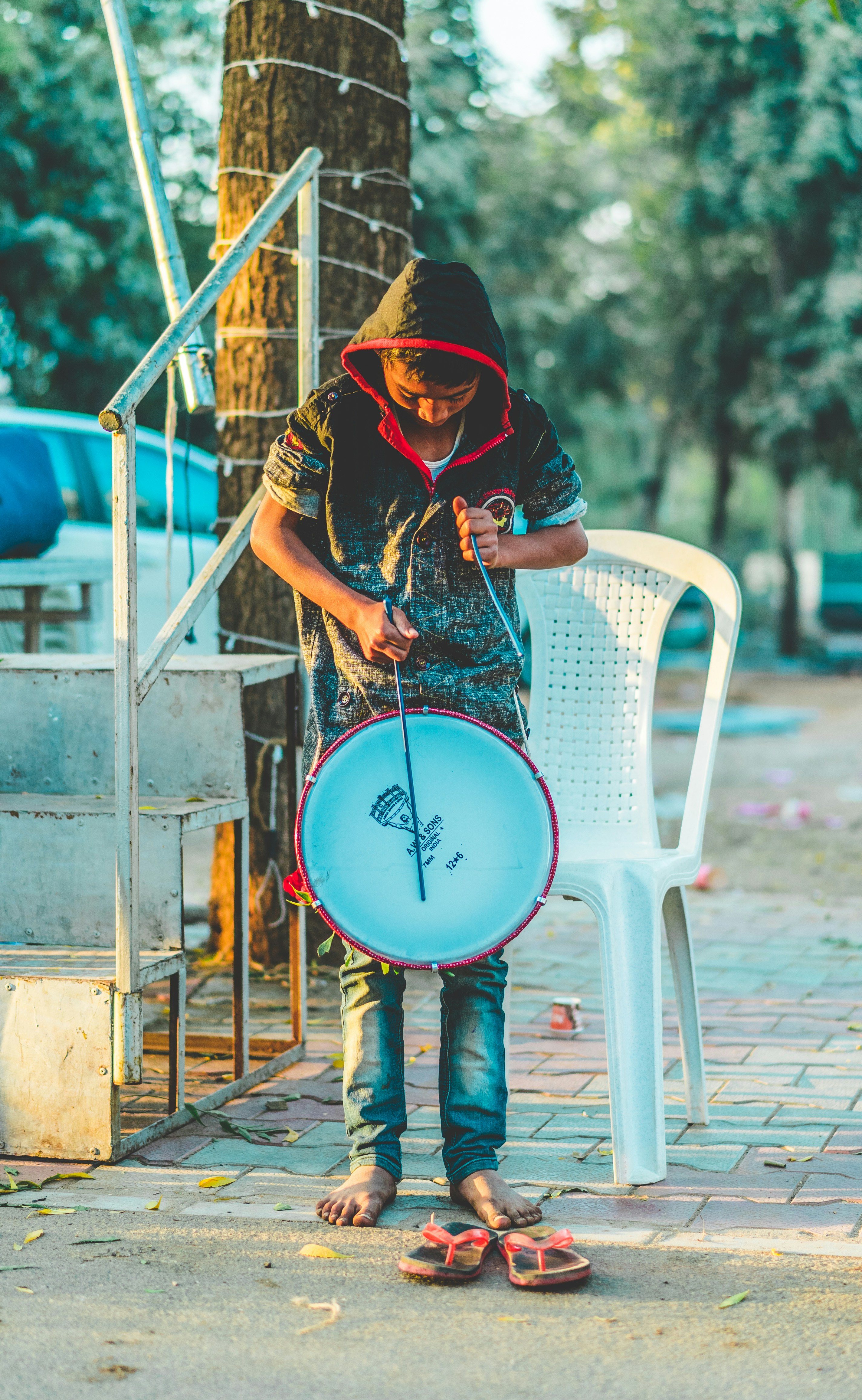 man standing while holding white drum at daytime