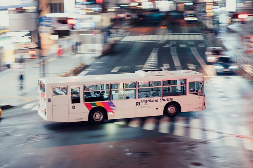 white bus on road at nighttime