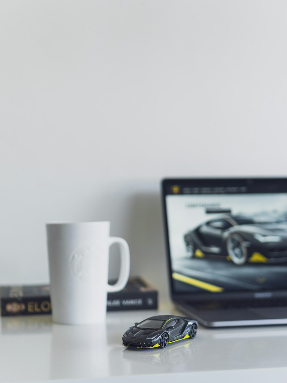 black sports car miniature beside white mug