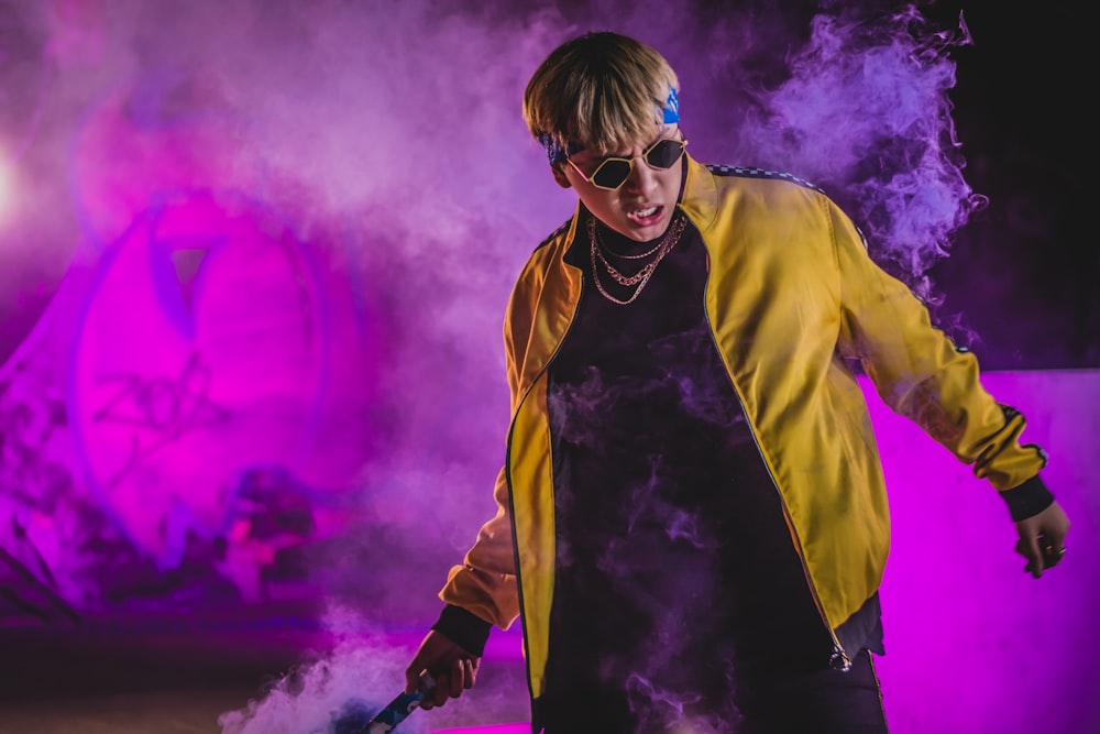man wearing yellow jacket and brown framed sunglasses with smoke effects