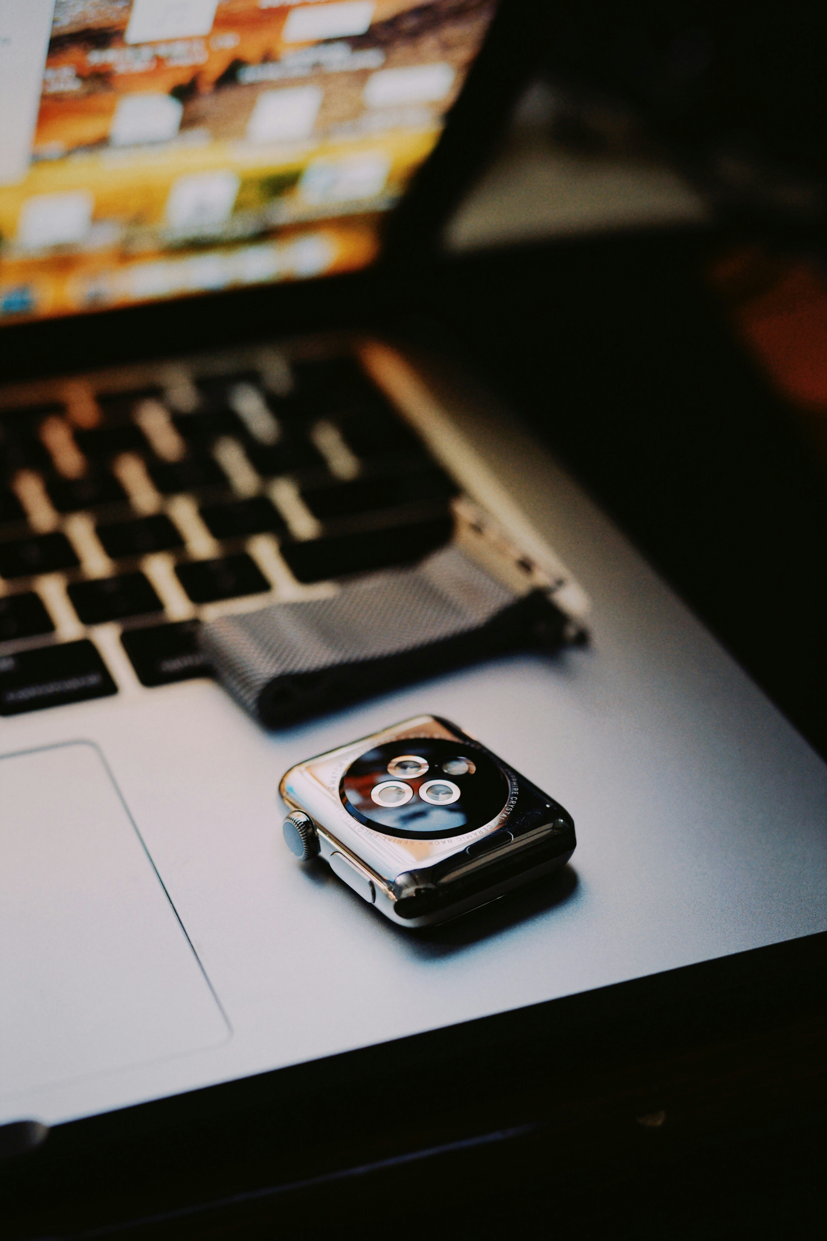 silver Apple watch on MacBook Pro