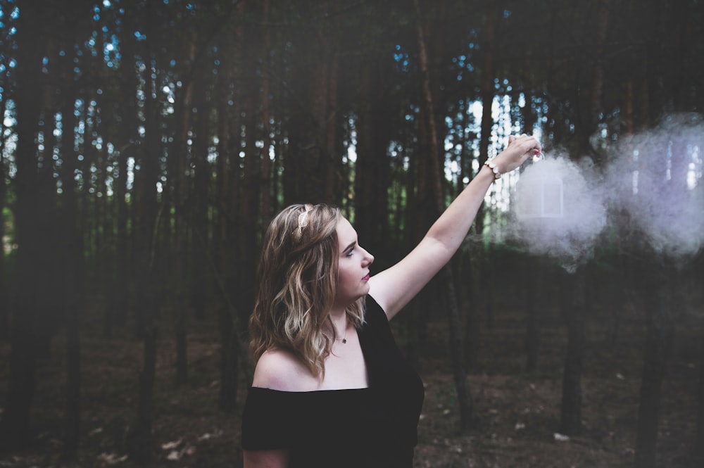 selective focus photography of woman standing near forest