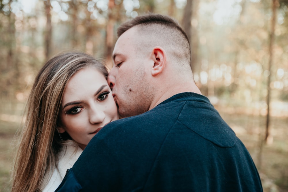 shallow focus photo of man kissing woman