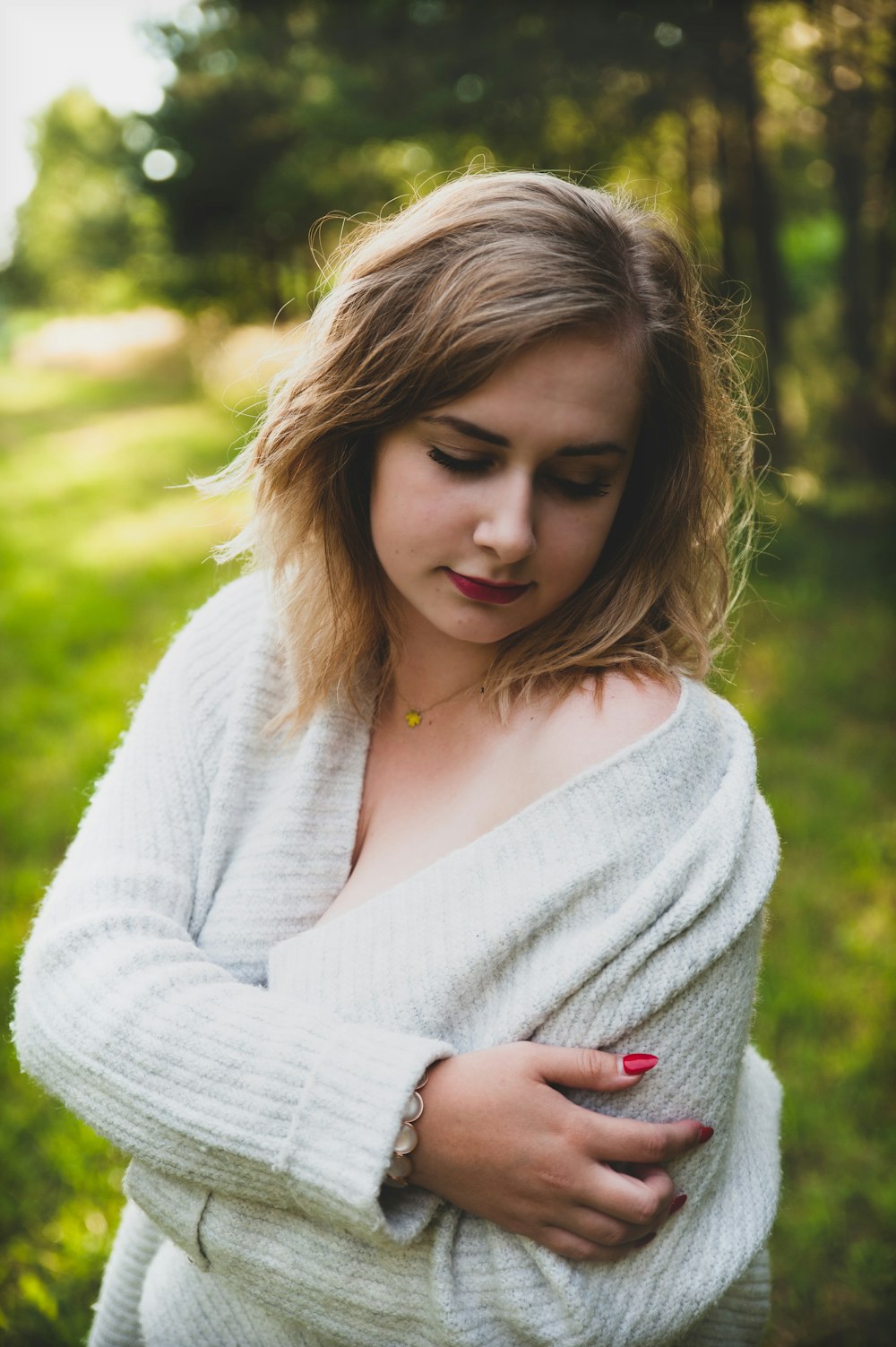 selective focus photography of woman holding shoulder