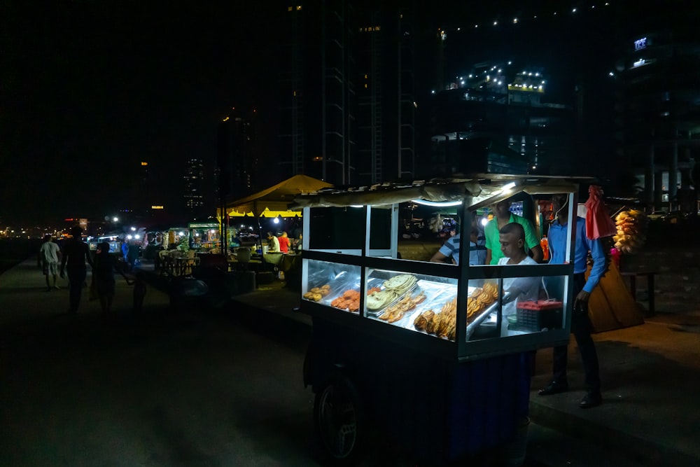 man standing in front of street food vendor