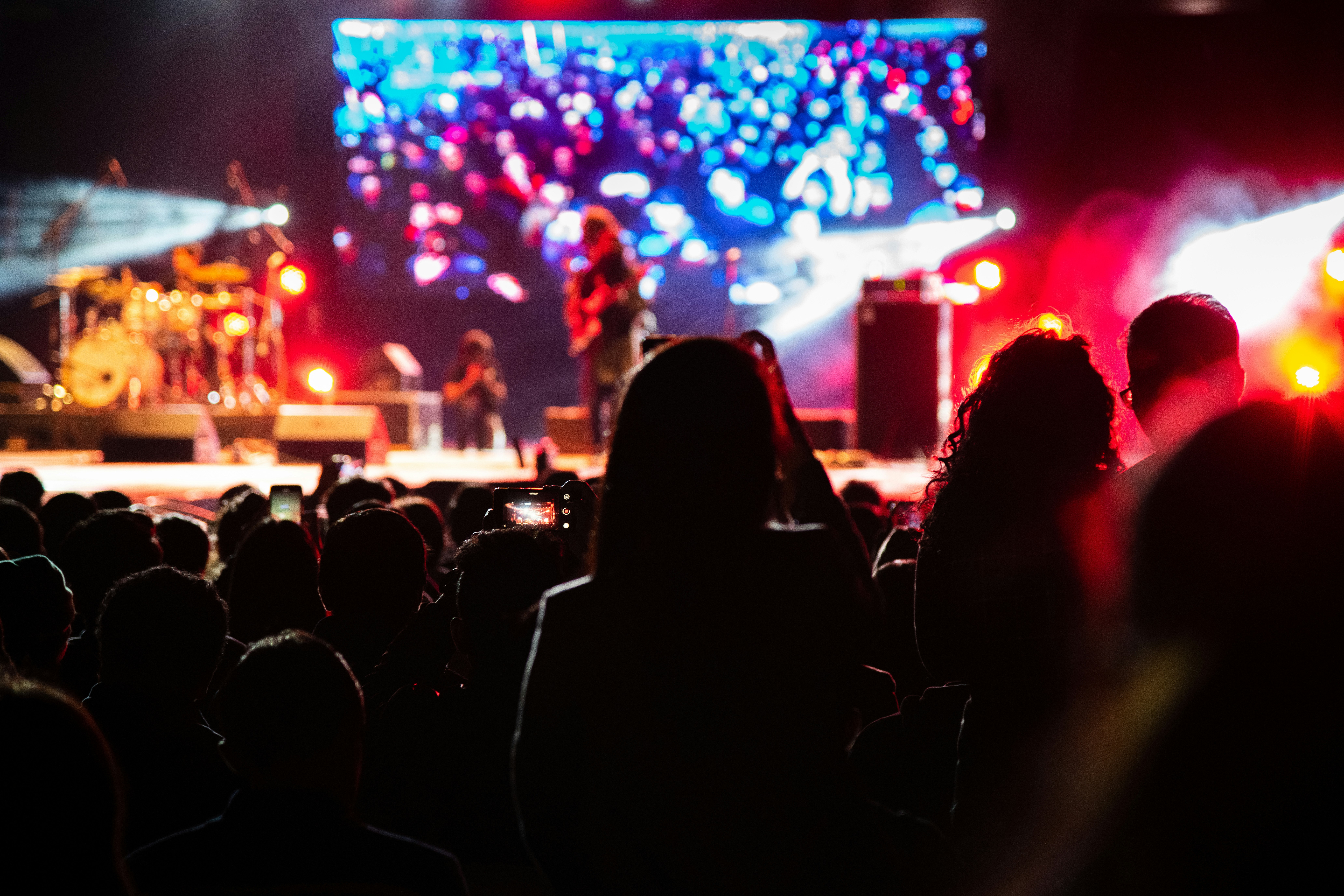 selective focus photography of woman standing near band group performing on stage