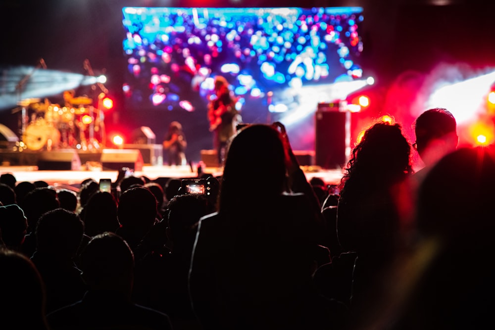 selective focus photography of woman standing near band group performing on stage