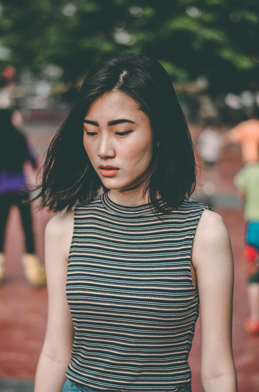 woman wearing brown and blue sleeveless shirt standing